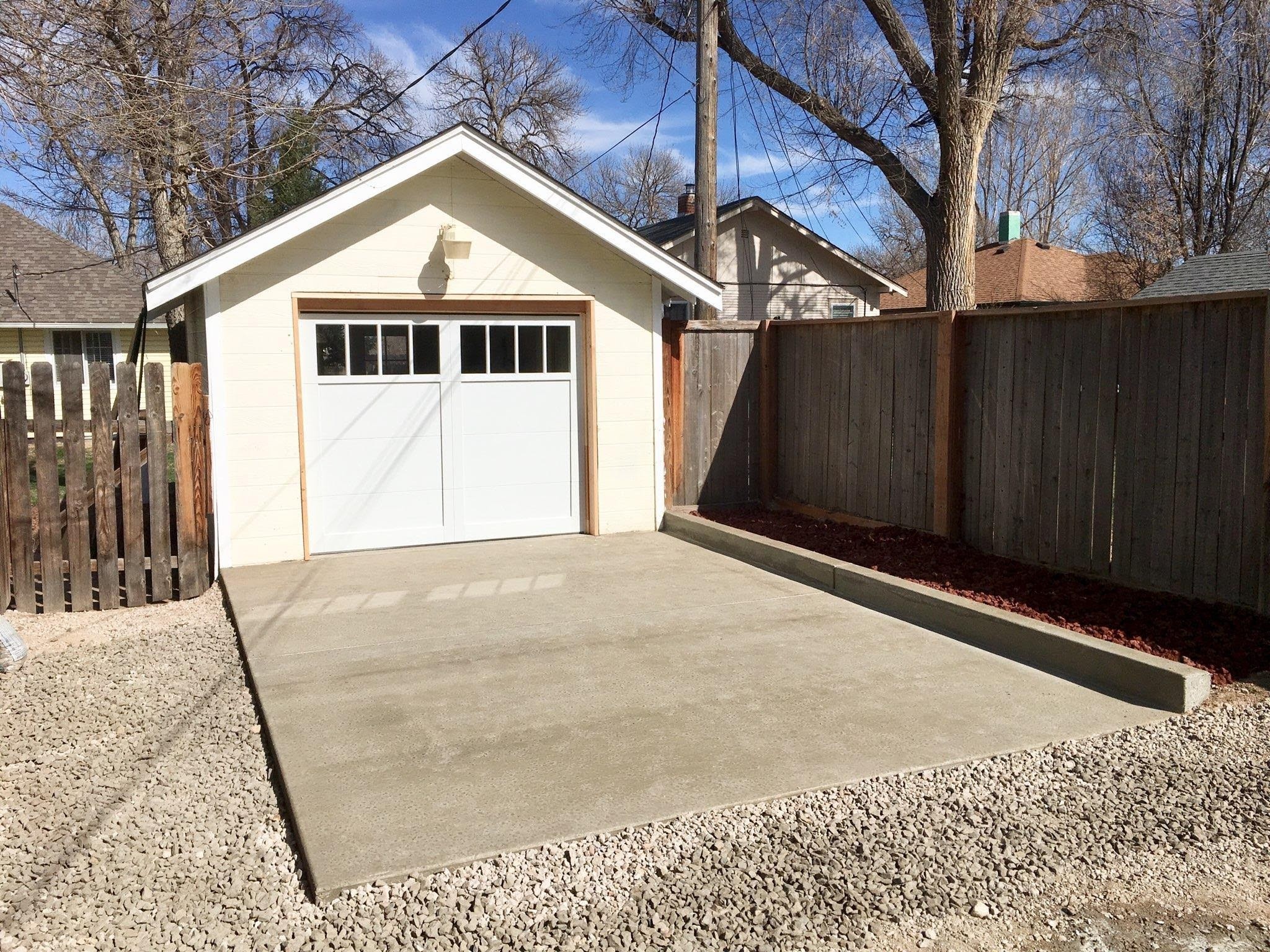 white detached garage with paved driveway