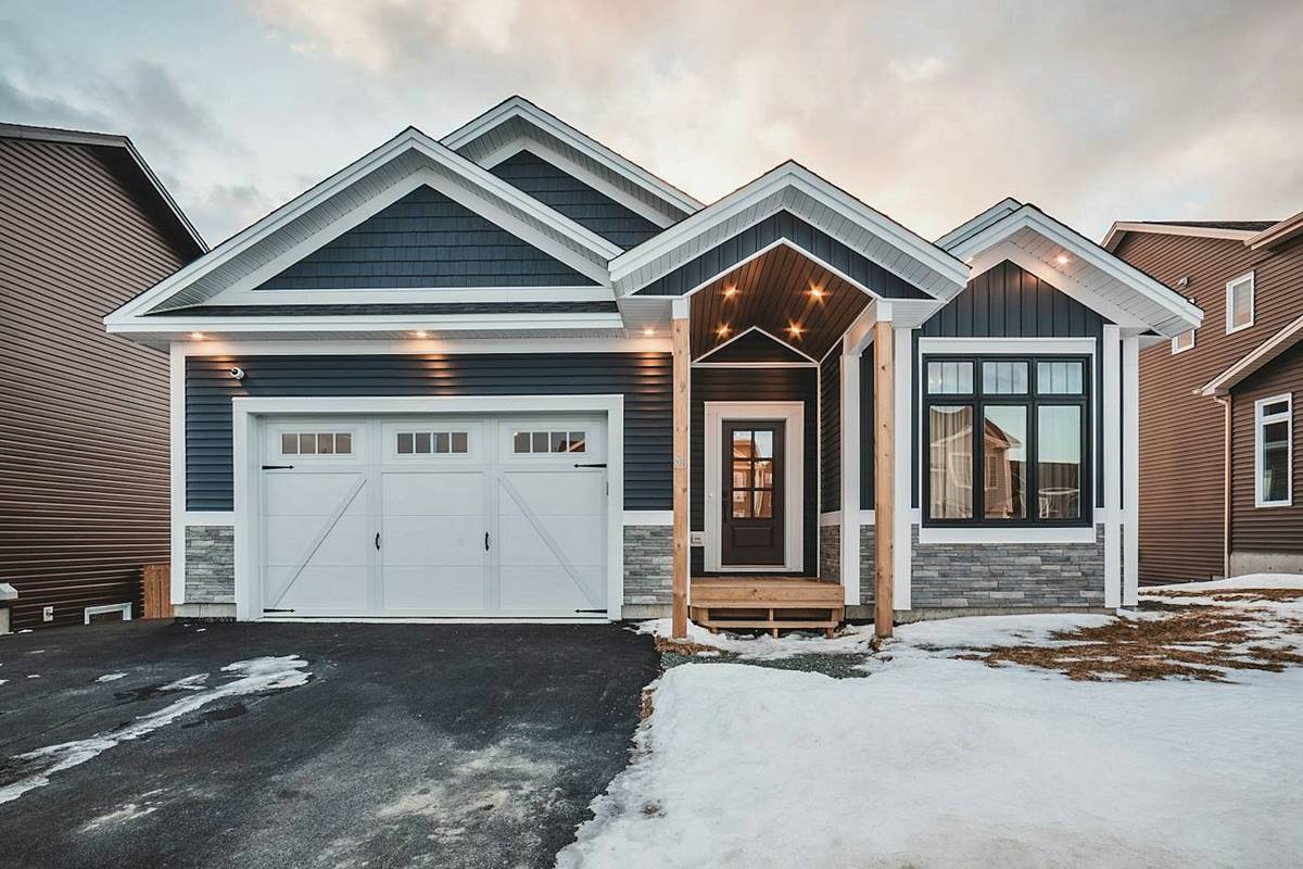 Single-story home with blue siding and white carriage style garage door
