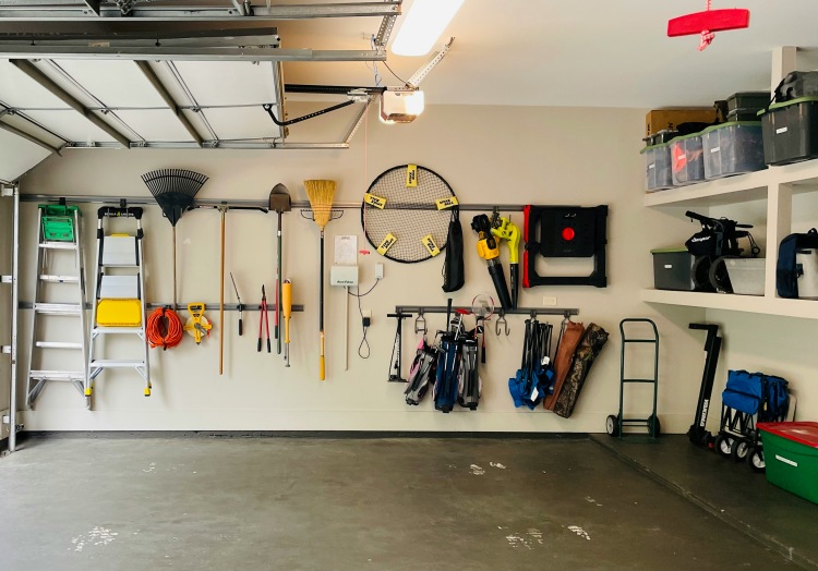 Organized two-car garage with open door and wall-mounted storage