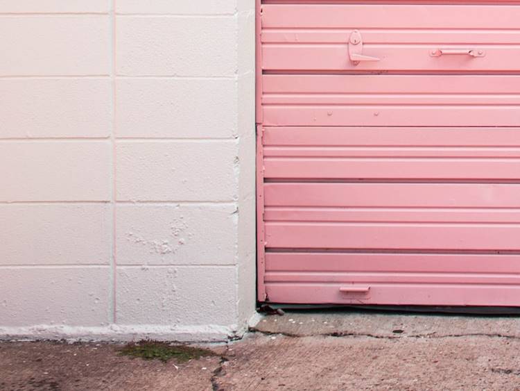White concrete garage with bright pink steel rolling garage door
