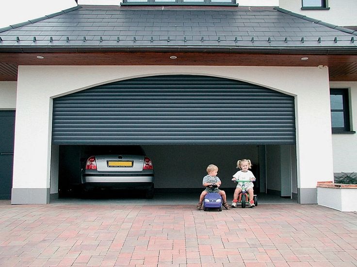 Garage door stuck halfway open with sedan inside and two toddlers in adjacent driveway