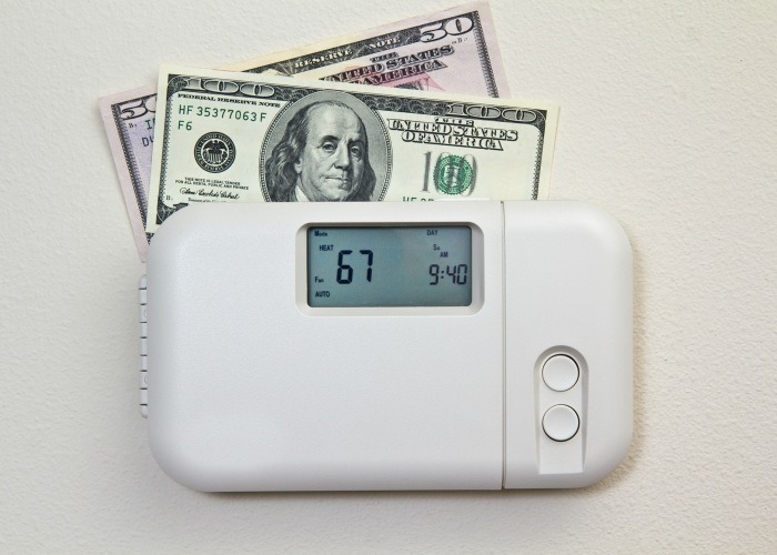 white thermostat with money behind