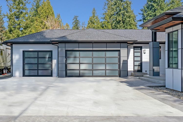 White one-story home with three-car garage and modern glass garage doors