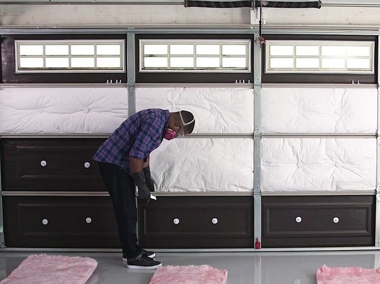 man installing insulation on garage door