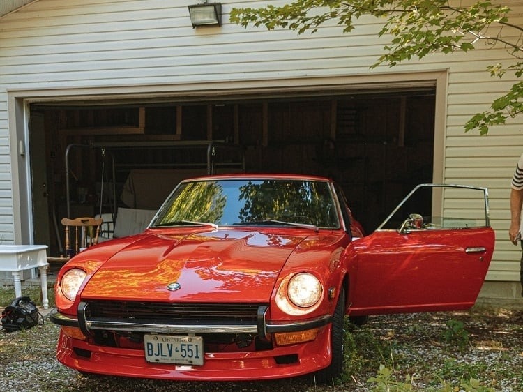 red car with opened garage door