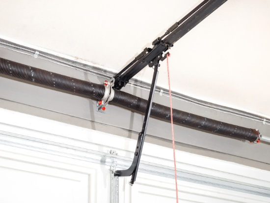 Two torsion springs mounted on a shaft above a garage door
