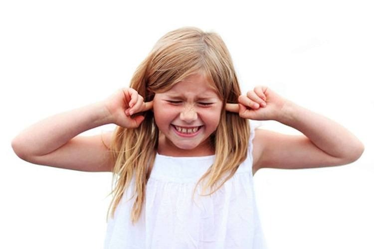 little girl plugging ears